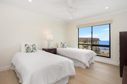 a white bedroom with two beds and a large window at Pacific Bliss - DMBC767 in Solana Beach