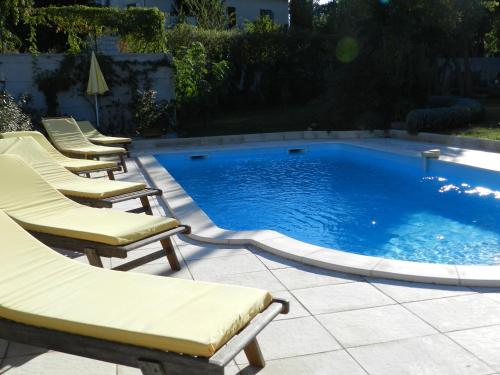 a row of chairs sitting next to a swimming pool at Les Broussous in Sauve