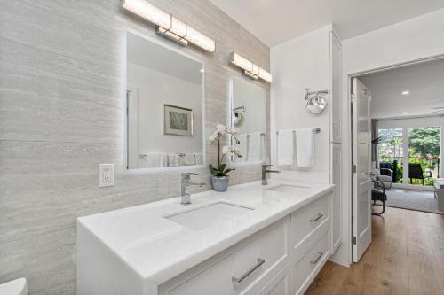 a white bathroom with a sink and a mirror at Fairway Haven - CB2507 in Carlsbad