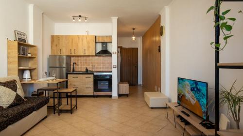 a living room with a couch and a kitchen at ILIRIA Apartment in Durrës