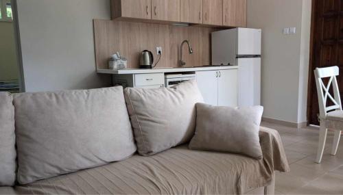 a couch with pillows in a kitchen with a refrigerator at Siódma Wyspa in Łupawsko