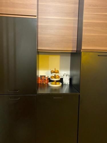 une cuisine avec des armoires noires et une assiette de nourriture dans l'établissement Cosy et Arty, à Paris