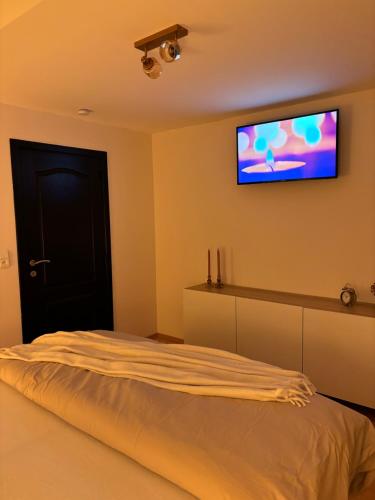 a bedroom with a bed with a television on the wall at Évasion à Durbuy in Famenne