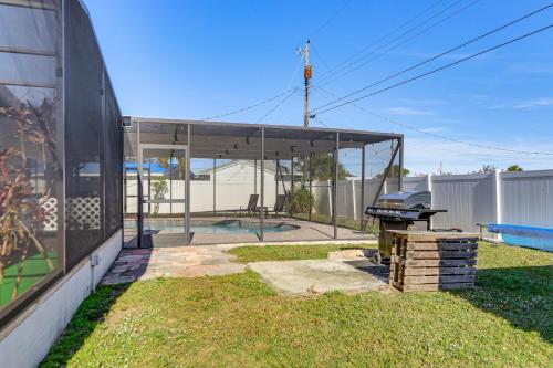 a barbecue grill in a yard next to a building at 4 Mi to Historic Dtwn Venice Home with Heated Pool! in Venice