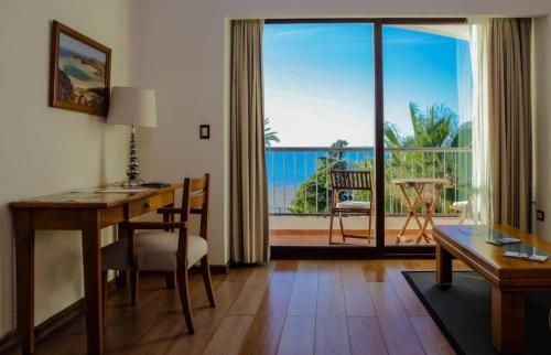 a living room with a desk and a view of a balcony at La Posada Hotel Boutique in La Paz
