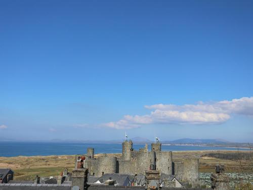 an old castle with the ocean in the background at Harlech Apartments - Matholwch in Harlech