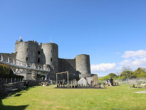 a castle with a playground in front of it at Harlech Apartments - Matholwch in Harlech