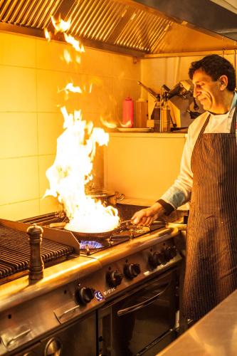 a man in a kitchen with a cake on a stove at Pamukkale Termal Ece Otel in Pamukkale