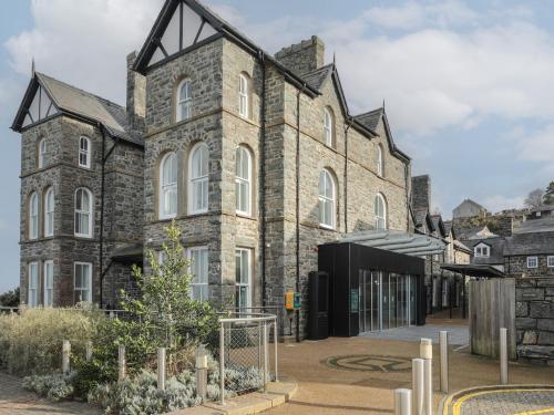 an old stone building with a courtyard in front of it at Harlech Apartments - Efnisien in Harlech