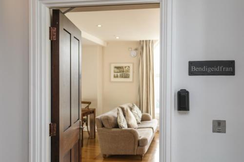 a door leading into a living room with a chair at Harlech Apartments - Bendigeidfran in Harlech