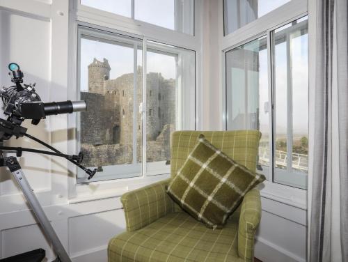 a camera operator taking a picture of a chair in a room with windows at Harlech Apartments - Bendigeidfran in Harlech