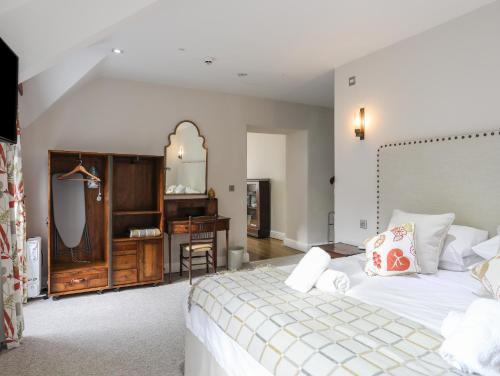a bedroom with a bed and a desk and a mirror at Harlech Apartments - Bendigeidfran in Harlech
