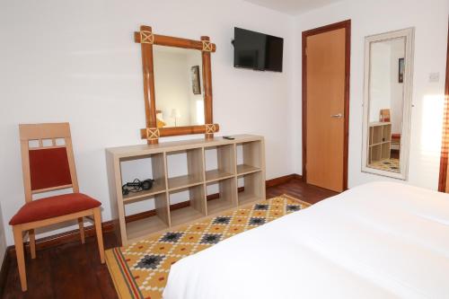 a bedroom with a bed and a mirror and a chair at The Redburn in Belfast