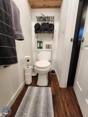 a bathroom with a toilet and a rug at The Fancy Fox - Frontier Village in North Pole