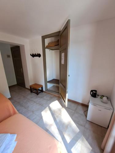 an empty room with a bed and a mirror at Hostal Playa in Cala Santanyi