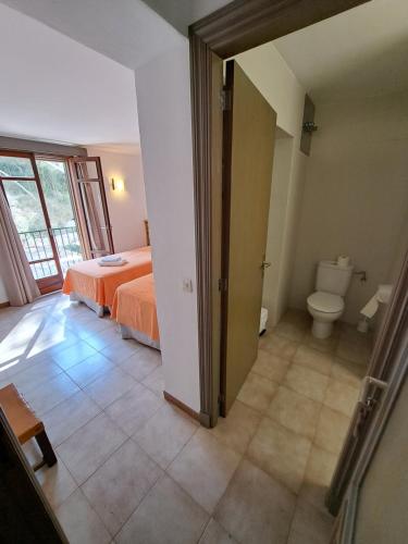 a bedroom with a bed and a toilet in a room at Hostal Playa in Cala Santanyi