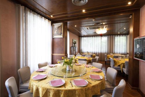 a dining room with a round table with pink napkins at Hotel Vienna in Marghera