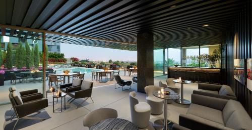 a hotel lobby with tables and chairs and a pool at AKA West Hollywood in Los Angeles