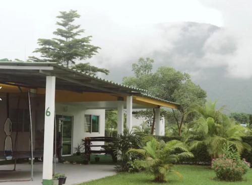 a small white house with a porch at Tao Life Center in Ban Mae Khon
