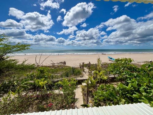 a view of a beach with a bench and the ocean at Stella Mar Oceanfront Hotel in Popoyo