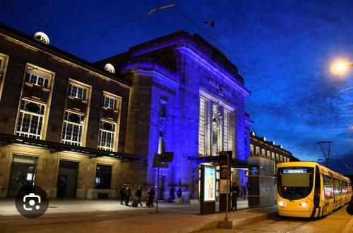un bus jaune garé devant un bâtiment à éclairage bleu dans l'établissement Halim, à Mulhouse