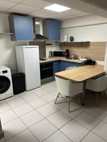 une cuisine avec une table en bois et un réfrigérateur dans l'établissement Halim, à Mulhouse