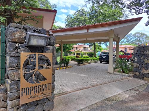 a sign on a stone wall in front of a building at Papagayo Hotel y Villas in Playa Panama
