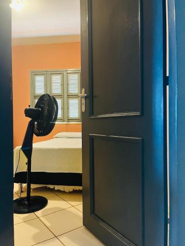 a door with a fan in a room with a bed at Hospedagem da Cleidiane in Icapuí