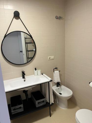 a bathroom with a sink and a mirror and a toilet at Balcón del Júcar delux in Tragacete