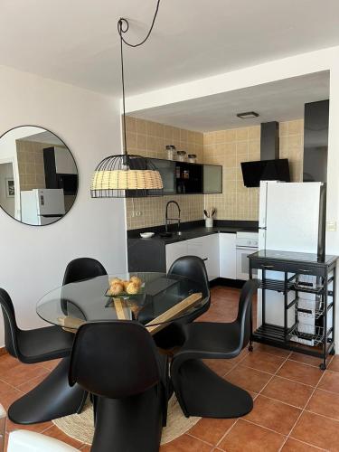 a dining room with a table and black chairs at Balcón del Júcar delux in Tragacete