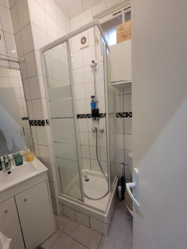 Un baño con ducha, inodoro y lavabo. en Logement entier Pantin, en Pantin