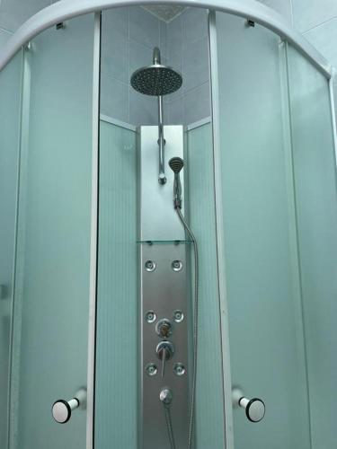 d'une douche avec une porte en verre et un pommeau de douche. dans l'établissement Studio cabine nouveau ! 1ère ligne vue mer PARKING WIFI - Impérial 2 - ROSSIconciergerie - Linge en option, à La Grande Motte