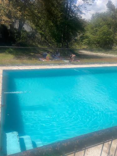a blue swimming pool with people in the background at Cabaña las Trancas in Las Trancas
