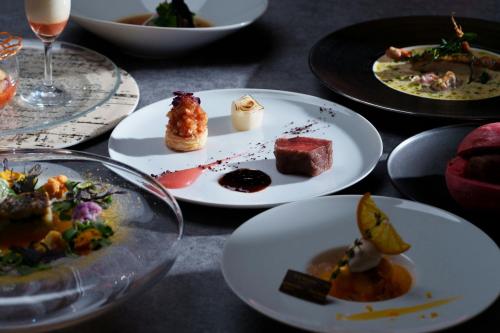a table with plates of food and glasses of wine at The Westin Sendai in Sendai
