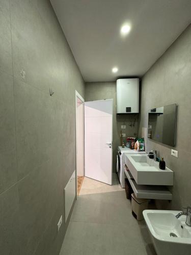 a bathroom with two sinks and a white door at The Best Shkoder in Shkodër