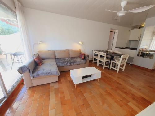 un salon avec un canapé et une table dans l'établissement T2 familial 1ère ligne plages Parking privé WIFI - Le Foc - ROSSIconciergerie - Linge en option, au Grau-du-Roi