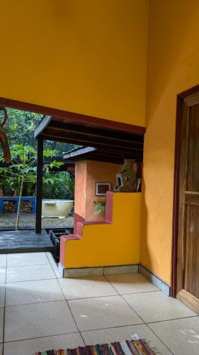a yellow wall with a staircase in a house at Tree House Beachfront Lodge in Puerto Viejo