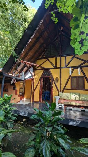 a house with a bench in front of it at Tree House Beachfront Lodge in Puerto Viejo