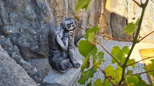 a statue of a woman sitting on a rock at Pedra Oliveira in Ameixeira