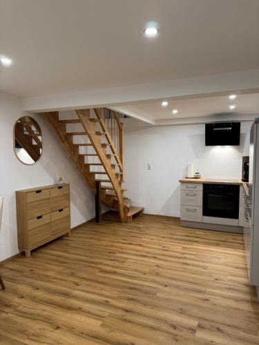 a room with a staircase and a kitchen with wooden floors at Isaak Apartment Lottstetten in Lottstetten