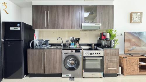 a kitchen with a washing machine and a washer at Peaceful Al Reef Studio - King Bed Comfort for 2 Near Community Park in Abu Dhabi