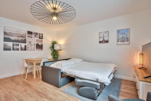 - une chambre avec un lit et une table avec un bureau dans l'établissement Superbe appartement aux portes de Paris WIFI et TV, à Clichy