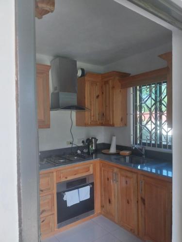 a kitchen with wooden cabinets and a stove top oven at Jamaica Beach in Tower Isle