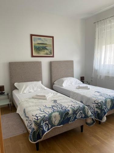two beds sitting next to each other in a bedroom at Apartment Divald in Osijek