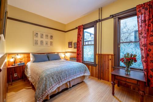 a bedroom with a bed and two windows at Victoria Falls House Inn in Nelson