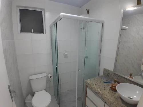 a bathroom with a shower and a toilet and a sink at Apartamento, 5 minutos da praia in Porto Belo