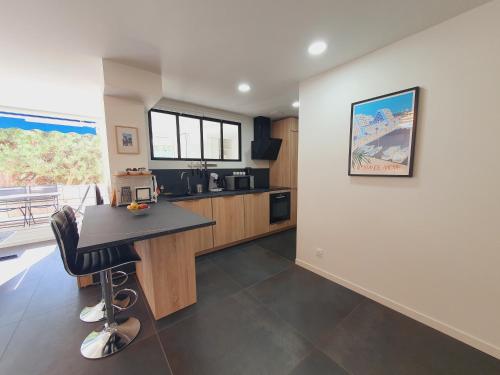 une cuisine avec une table et un bureau. dans l'établissement T2 cœur de ville moderne CLIM WIFI Terrasse - ROSSIconciergerie - Linge en option, à La Grande Motte