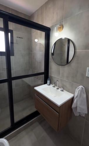 a bathroom with a sink and a shower with a mirror at Cerros de Cafayate, Casa Nº1 in Cafayate