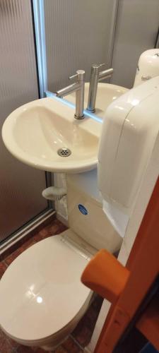a bathroom with a white toilet and a sink at Apartamento-Habitación Palonegro Manizales in Manizales