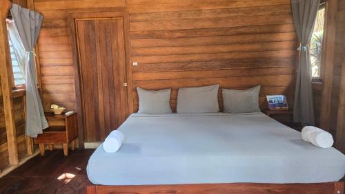 a bedroom with a blue bed with a wooden wall at bacalar My Love Front Laguna in Bacalar